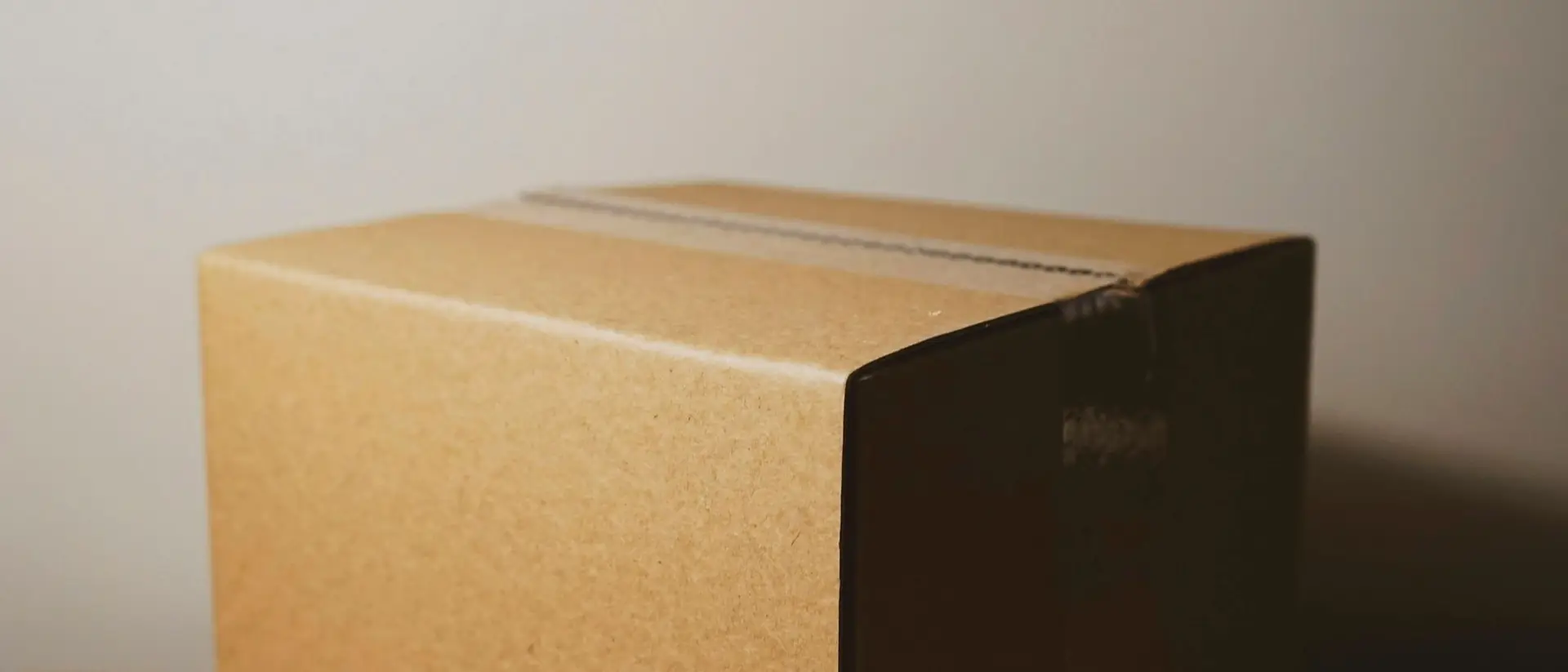 A plain cardboard box on a wooden surface